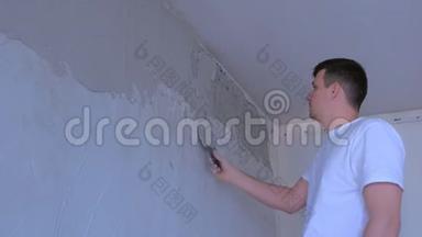 粉刷工人用腻子粉刷墙面，用石对齐墙面。